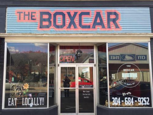 Front view of The Boxcar restaurant, featuring large red signage, open door, and a welcoming atmosphere.