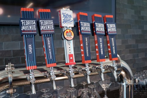 A row of beer taps with colorful handles from Florida Avenue Brewing Co., featuring various beer options.