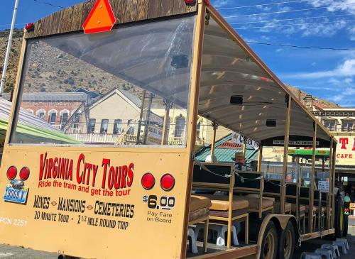 A tour tram in Virginia City, featuring seating and a sign for a 20-minute tour at $6 fare.