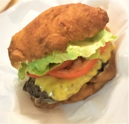 A juicy cheeseburger with melted cheese, lettuce, and tomato, served in a toasted bun.