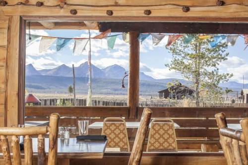 View from a rustic restaurant window showcasing mountains and colorful prayer flags against a clear blue sky.