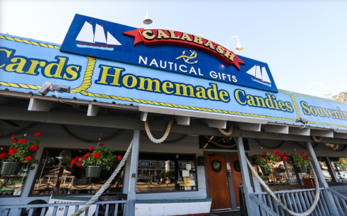 A colorful storefront of Calabash Nautical Gifts, featuring signs for cards, homemade candies, and souvenirs.
