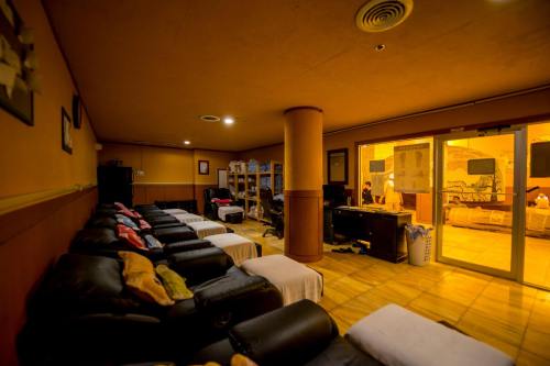 A cozy lounge area with reclining chairs, a desk, and bunk beds, softly lit with warm yellow tones.