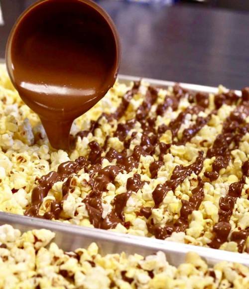 A tray of popcorn drizzled with melted chocolate, creating a sweet and savory treat.