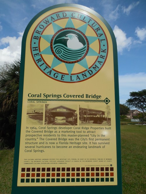 Sign for Coral Springs Covered Bridge, detailing its history and significance as a Florida Heritage Site.
