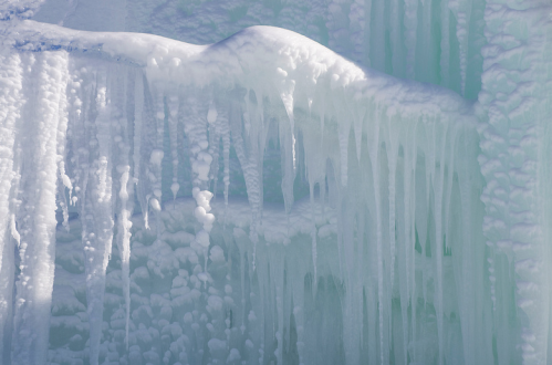 Icicles and frozen formations create a textured, icy landscape in shades of blue and white.