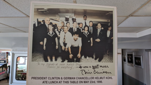 A group photo of President Clinton and Chancellor Kohl with diners at a restaurant, signed by Clinton.