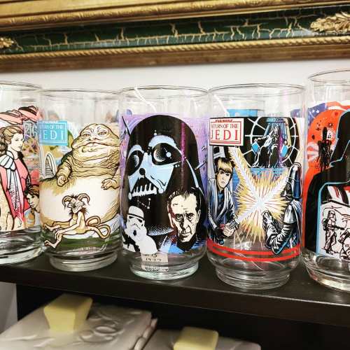 A collection of Star Wars-themed glasses featuring characters like Jabba, Darth Vader, and Luke Skywalker.