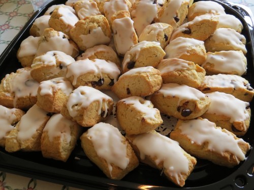 A large tray of freshly baked scones topped with a glossy white icing.