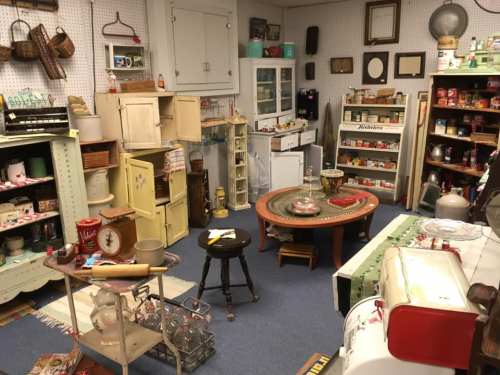 A cozy vintage shop filled with various antiques, furniture, and collectibles on display in a well-organized space.