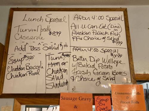 Menu board displaying lunch specials, including tuna noodle casserole, salads, and after 4 PM specials.