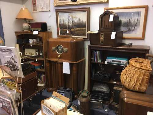 A cozy antique shop filled with vintage furniture, radios, and decor, showcasing a nostalgic atmosphere.