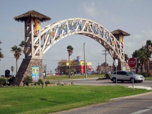 A colorful archway sign reading "North Beach" with palm trees and a beach-themed backdrop.