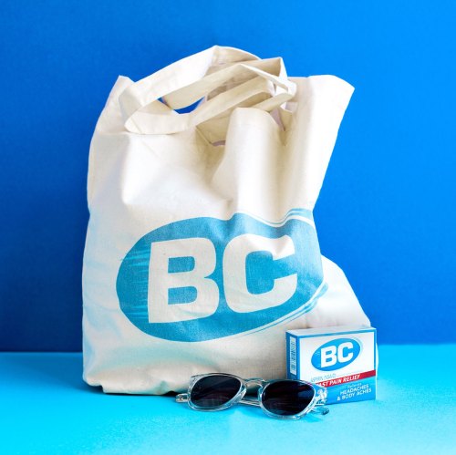 A canvas bag with "BC" logo next to a box of BC pain relief and a pair of sunglasses on a blue background.