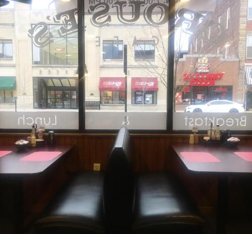 Interior of a diner with two empty booths facing a large window, showing a street view outside.