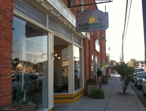 Exterior of Los Tejaban, a family Mexican restaurant, featuring a sign and a sidewalk with parked cars.