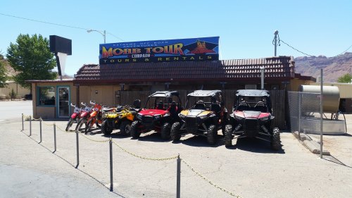 A rental shop with various ATVs and dirt bikes parked outside, under a sign for Moab Tour Tours & Rentals.