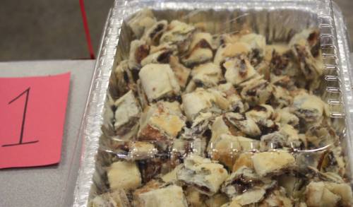 A tray of small, square pieces of pastry with a chocolate filling, covered in powdered sugar.