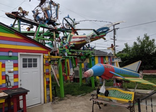 Colorful, whimsical structures and sculptures resembling airplanes and rockets in a vibrant outdoor setting.