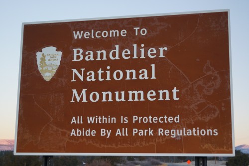 Welcome sign for Bandelier National Monument, highlighting park regulations and protection of the area.