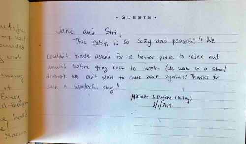 A handwritten guestbook entry expressing gratitude for a cozy cabin stay, signed by Michelle and Eugene on 9/1/2019.