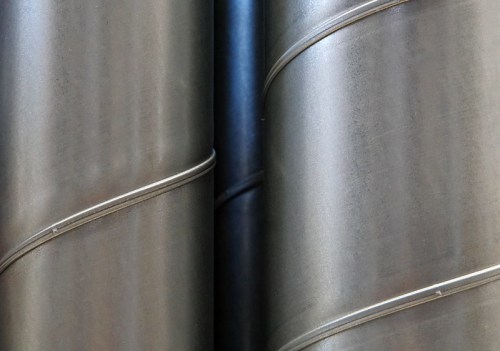 Close-up of metallic pipes with a smooth, shiny surface and subtle curves, reflecting light.