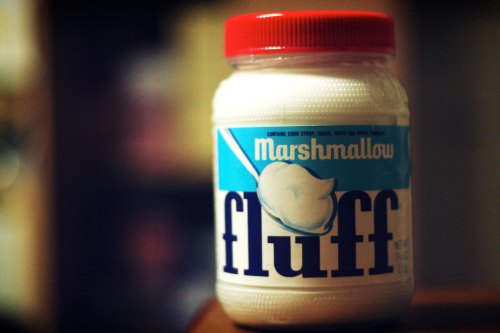 A jar of marshmallow fluff with a red lid and blue label, featuring the word "fluff" in bold letters.