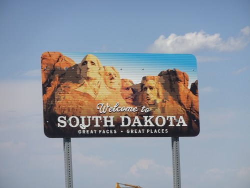 Welcome sign for South Dakota featuring Mount Rushmore and the tagline "Great Faces, Great Places."