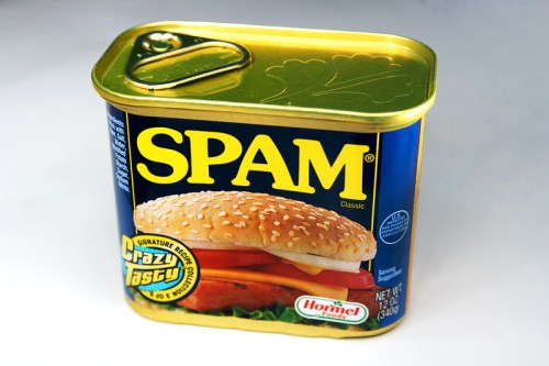 A can of Spam Classic featuring a sandwich on the label, with a gold lid and blue background.