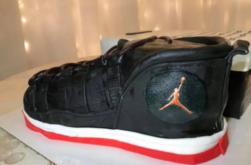 A cake designed to look like a black and red Air Jordan sneaker, featuring the iconic Jumpman logo.