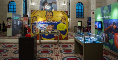 Exhibit showcasing Superman memorabilia with colorful displays and interactive elements in a museum setting.