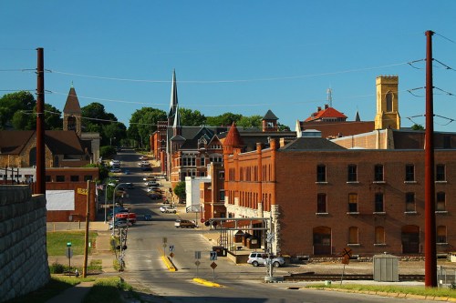 A scenic view of a small town with historic brick buildings, churches, and a clear blue sky.
