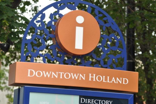 Sign for Downtown Holland featuring an information icon and decorative design.