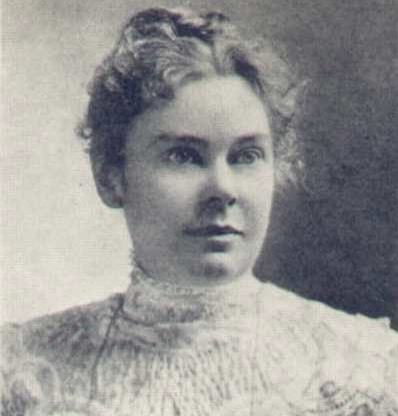 Black and white portrait of a woman with curly hair, wearing a lace blouse, looking directly at the camera.