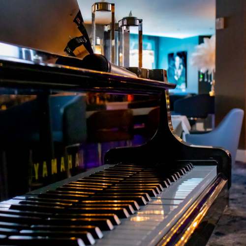 Close-up of a Yamaha piano keyboard with elegant decor and soft lighting in the background.