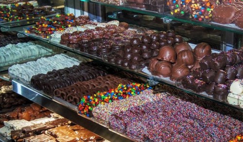 A display of various chocolates and candies, including chocolate-covered treats and colorful sprinkles.