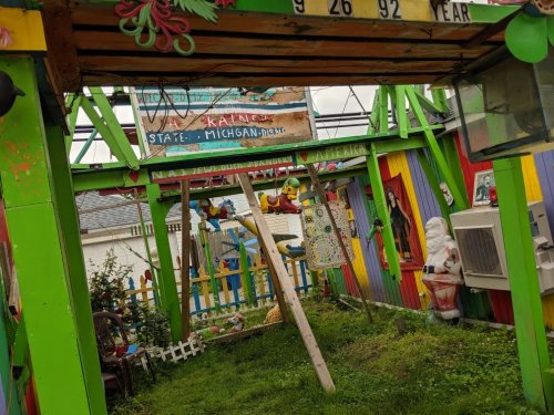 Colorful, whimsical outdoor space with vibrant walls, playful decorations, and a swing set in a garden setting.