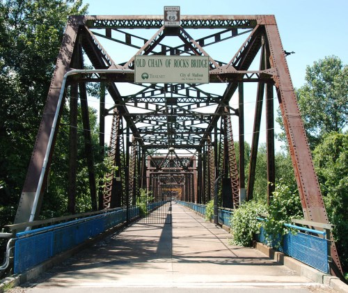Old Chain of Rocks Bridge, a metal truss bridge with greenery, under a clear blue sky, part of Route 66.