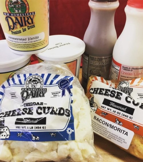 Assorted dairy products including ice cream, cheese curds, and milk bottles on a red background.
