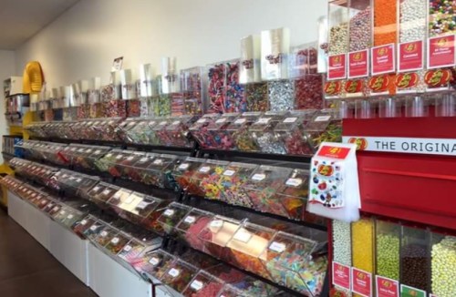 A colorful candy store display with various jars filled with different types of candies and sweets.