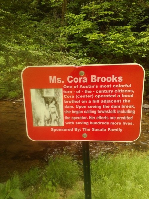 Sign about Ms. Cora Brooks, highlighting her efforts to save lives during a dam break in Austin, sponsored by the Sasala Family.