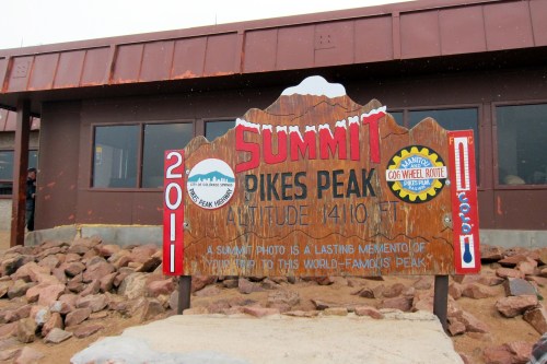Sign at the summit of Pikes Peak, displaying altitude and a message about capturing memories from the famous peak.