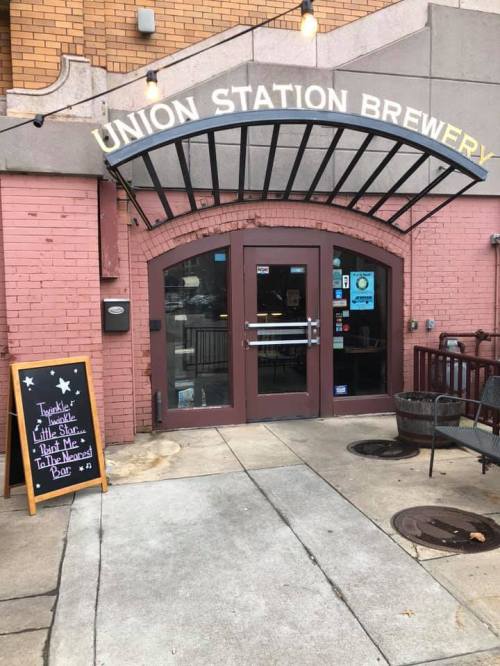 Entrance to Union Station Brewery with a signboard and outdoor seating area.