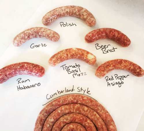 Various types of sausages labeled on a white surface, including Polish, Garlic, Beer Brat, and more.