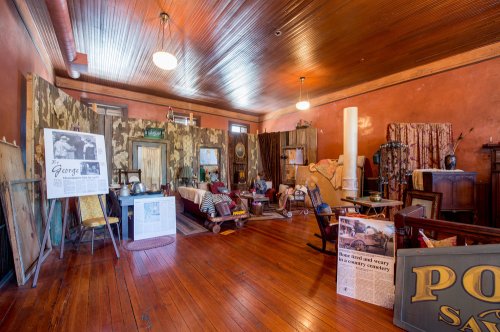 A vintage room with wooden floors, old furniture, and historical decor, creating a nostalgic atmosphere.