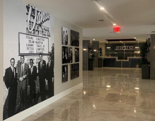 A hallway featuring a large black-and-white mural of classic entertainers and a modern reception area labeled "LEGENDS."