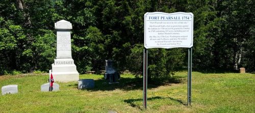 Historical markers and monuments at Fort Pearsall, surrounded by trees and a grassy area.