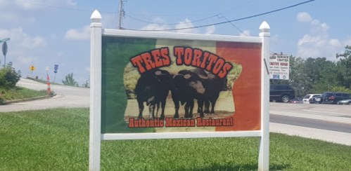 Sign for "Tres Toritos," an authentic Mexican restaurant, featuring a colorful design with three bulls.