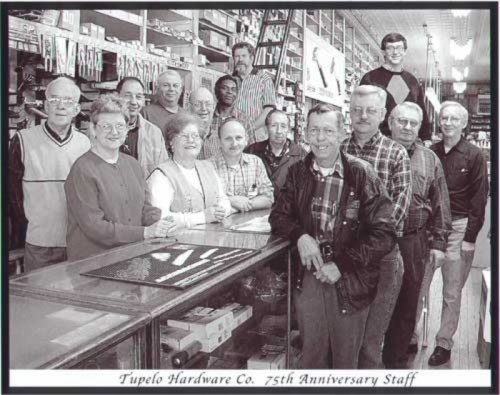 Black and white photo of the Tupelo Hardware Co. staff celebrating their 75th anniversary, posing together in the store.
