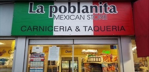 Sign for "La Poblana Mexican Store" featuring red, white, and green colors, with "Carniceria & Taqueria" below.